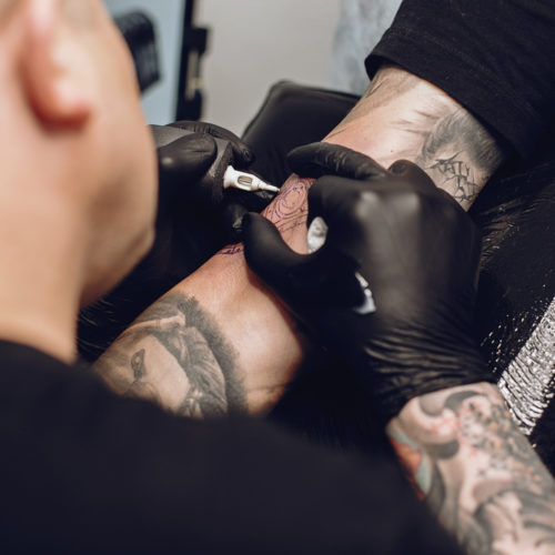 man-doing-tattoo-in-tattoo-salon